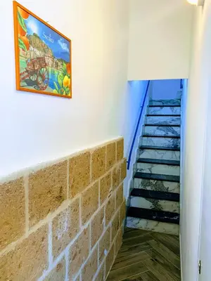 a staircase with a brick wall and a picture on the wall at Seafront House Gabbiano Azzurro in Santa Flavia