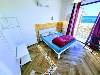a small room with a bed and a window at Seafront House Gabbiano Azzurro in Santa Flavia
