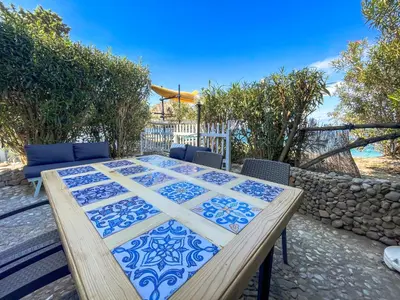 a wooden table with a blue and white quilt on it at Dimore di mare - Beachfront Apartments in Santa Flavia