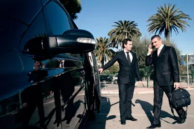 two men in suits are standing next to a car at Arricàmpati Airport Rooms & Bringo Car Rental in Carini