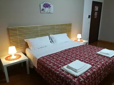 a bedroom with a bed with a red blanket and two lamps at La Dimora dei sette Arcangeli in Palermo