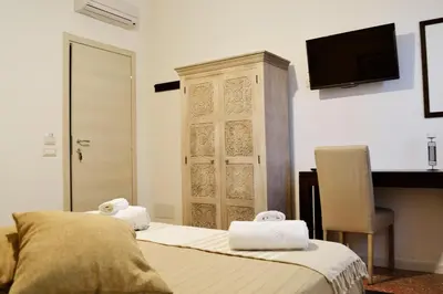 a bedroom with a bed and a tv on the wall at Piazza Marina in Palermo
