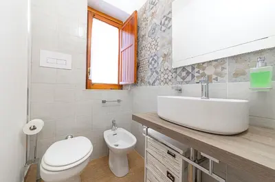 a white bathroom with a sink and a toilet at Maison Blanche in Palermo