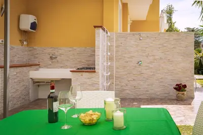 a green table with a bottle of wine and glasses at Maison Blanche in Palermo