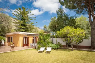 a house with a yard with chairs and trees at Maison Blanche in Palermo