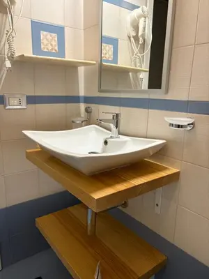 a bathroom with a white sink and a mirror at B&B Timpe Bianche in Castelluzzo