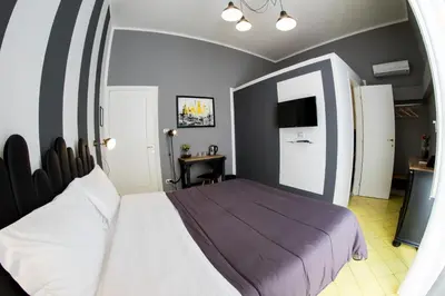 a bedroom with a large bed and a desk at Balate Maqueda B&B in Palermo