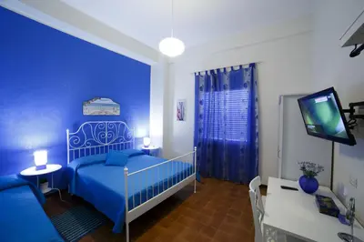a blue bedroom with a bed and a tv at Vista sul porto in Palermo