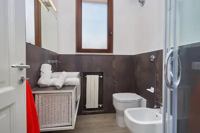 a bathroom with a toilet and a sink and a mirror at Villa Tarì in Scopello