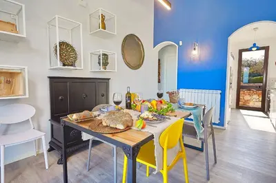 a dining room with a table and yellow chairs at Villa Tarì in Scopello