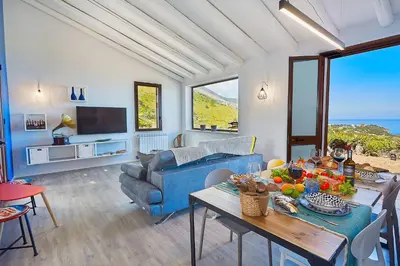 a living room with a blue couch and a table at Villa Tarì in Scopello
