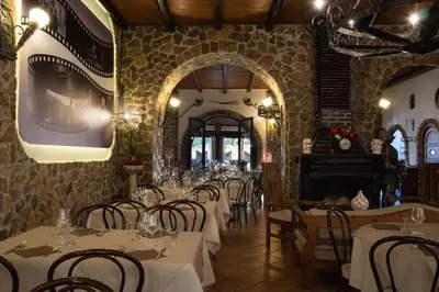 a dining room with tables and chairs and a fireplace at Hotel Castello di Giuliano in Montelepre