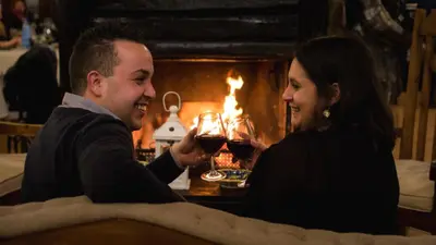 a man and woman drinking wine in front of a fireplace at Hotel Castello di Giuliano in Montelepre