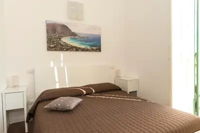 a bedroom with a bed with a picture on the wall at Ai Lattarini House in Palermo