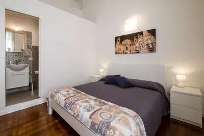 a bedroom with a bed and a bathroom with a sink at Ai Lattarini House in Palermo