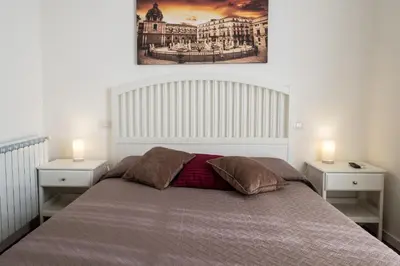 a bedroom with a large bed with two night stands at Ai Lattarini House in Palermo