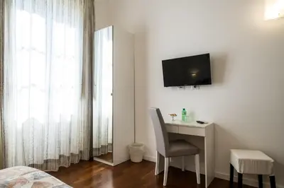 a bedroom with a desk and a television on a wall at Ai Lattarini House in Palermo