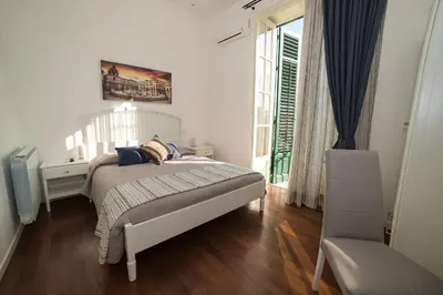 a white bedroom with a bed and a window at Ai Lattarini House in Palermo