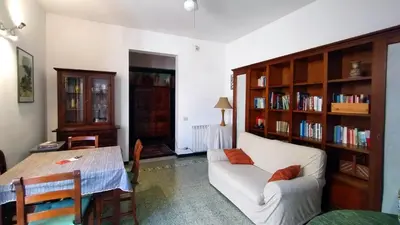 a living room with a couch and a table and book shelves at Appartamenti Olivuzza in Palermo