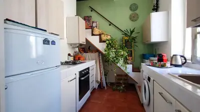 a kitchen with white appliances and a green wall at Appartamenti Olivuzza in Palermo