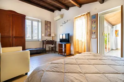 a bedroom with a bed and a desk and a television at Appartamenti Olivuzza in Palermo