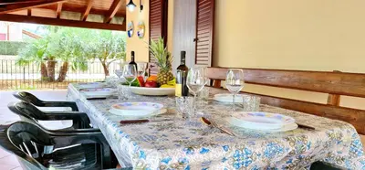 a long table with plates and wine glasses on it at Villa Paradiso in Alcamo Marina