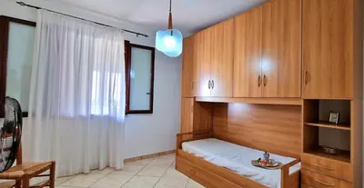 a bedroom with a bed and wooden cabinets at Villa Paradiso in Alcamo Marina