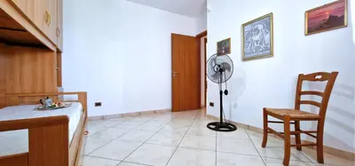 a room with a table and a fan and a chair at Villa Paradiso in Alcamo Marina