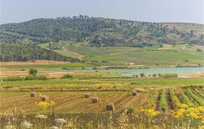 a field with hay bales in the middle of a mountain at Villa Belvedere in Sambuca di Sicilia
