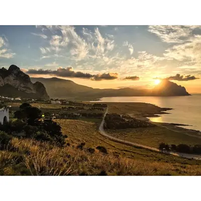 a sunset over the ocean with mountains in the background at Casa Azzurra by Un mare di Blu in Macari