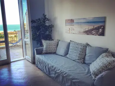 a couch in a living room with a view of the ocean at Casa Azzurra by Un mare di Blu in Macari