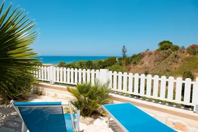 a blue table and chairs in front of a white fence at Villa Oleandro in Alcamo Marina