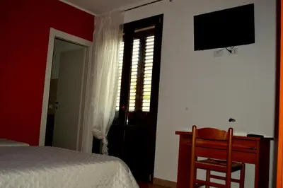 a bedroom with a bed and a desk and a television at B&B Federico II in San Cipirello