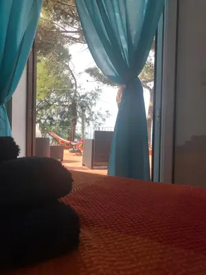 a blue curtain in front of a sliding glass door at Le Terrazze sul Mare - Capo Aranciotto Beach in Cefalù
