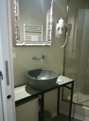 a bathroom with a bowl sink and a mirror at Persiane al Cassaro in Palermo