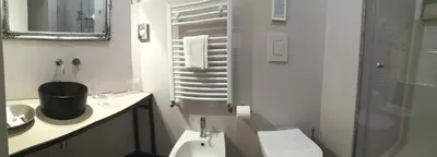 a white bathroom with a toilet and a sink at Persiane al Cassaro in Palermo
