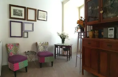 a living room with chairs and a table and a cabinet at Persiane al Cassaro in Palermo