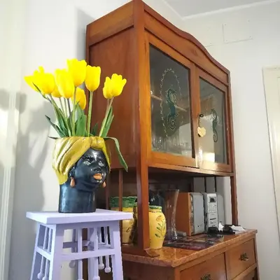 a vase with yellow flowers in it on a table at Persiane al Cassaro in Palermo