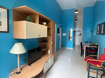 a living room with a tv and a blue wall at Belmonte Blu Suite in Palermo