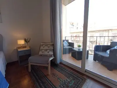 a living room with a couch and a chair and a balcony at Casa del Cioccolato in Palermo