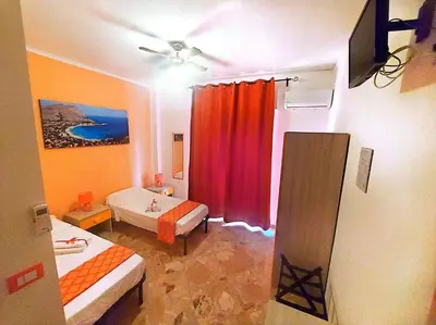 a room with two beds and a red curtain at B&B D'Amico87 in Bagheria