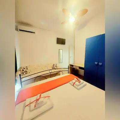 a bedroom with a bed and a blue cabinet at B&B D'Amico87 in Bagheria