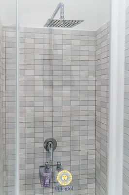 a tiled bathroom with a shower with a light at Giorgio I rooms in Palermo