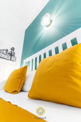 a bed with two yellow pillows on top of it at Giorgio I rooms in Palermo