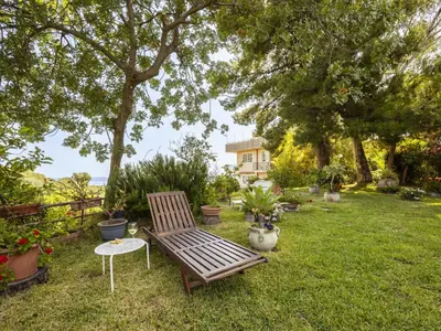 a wooden bench sitting in the grass in a yard at Apartment Cicladi Milos by Interhome in Santa Flavia