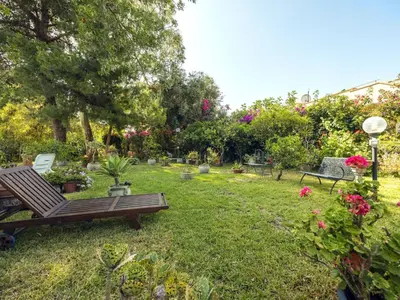 a garden with benches and flowers and plants at Apartment Cicladi Milos by Interhome in Santa Flavia