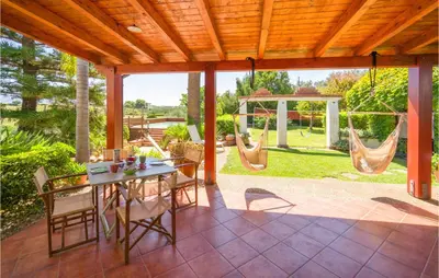 a patio with a table and chairs and swings at Beautiful Home In Partinico Pa in Balestrate