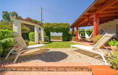 a patio with two lounge chairs and a swing at Beautiful Home In Partinico Pa in Balestrate