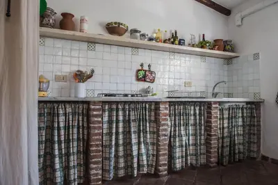 a kitchen with a counter with curtains on it at Ciuri Ciuri Mondello in Mondello