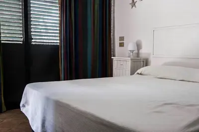 a bedroom with a white bed and a window at Ciuri Ciuri Mondello in Mondello